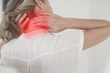 Person with poor posture experiencing neck pain at a desk